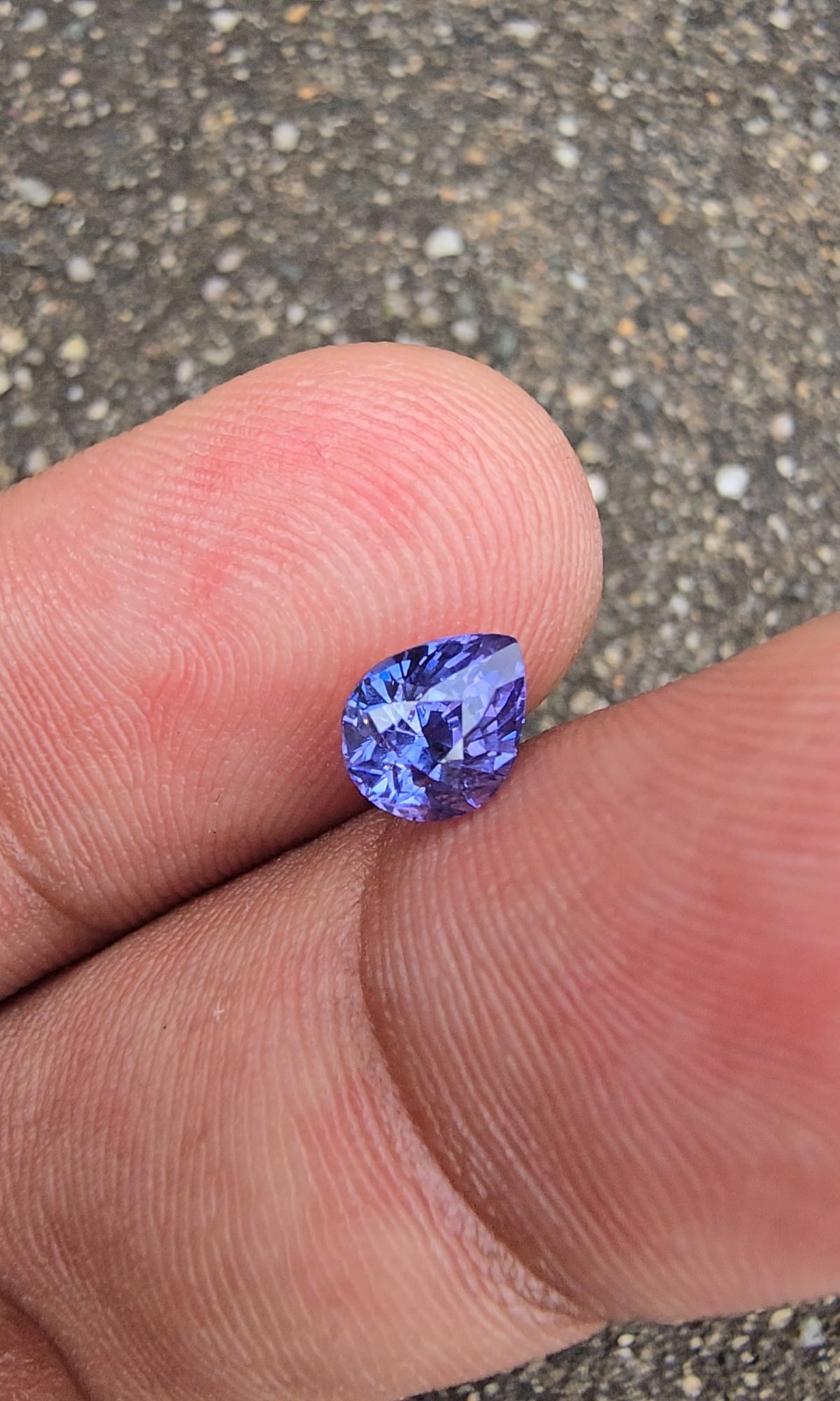 Close-up of violet pear-shaped sapphire with its point angled to the right