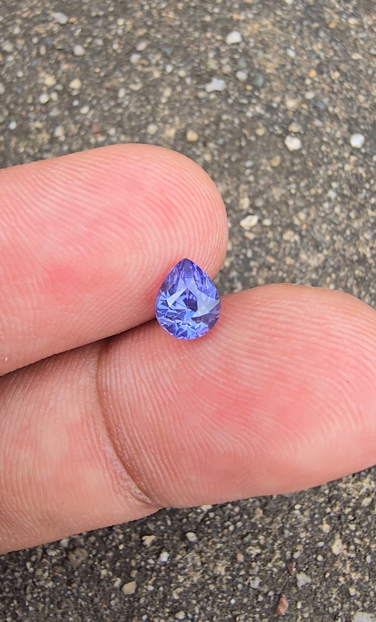 Face-up view of violet pear-cut sapphire showing its faceted surface